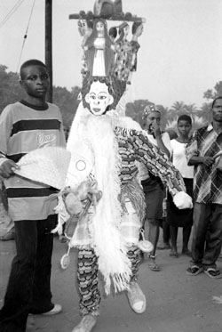 Fig. 1A masquerader surrounded by spectators. Note the tightly worn costume