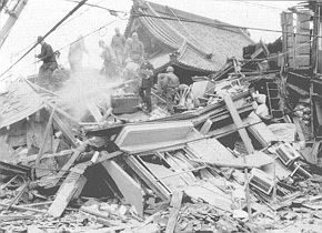 Fig. 4 - Collapsed old wooden house. Rescue squads of police and selfdefence forces searching for buried persons.